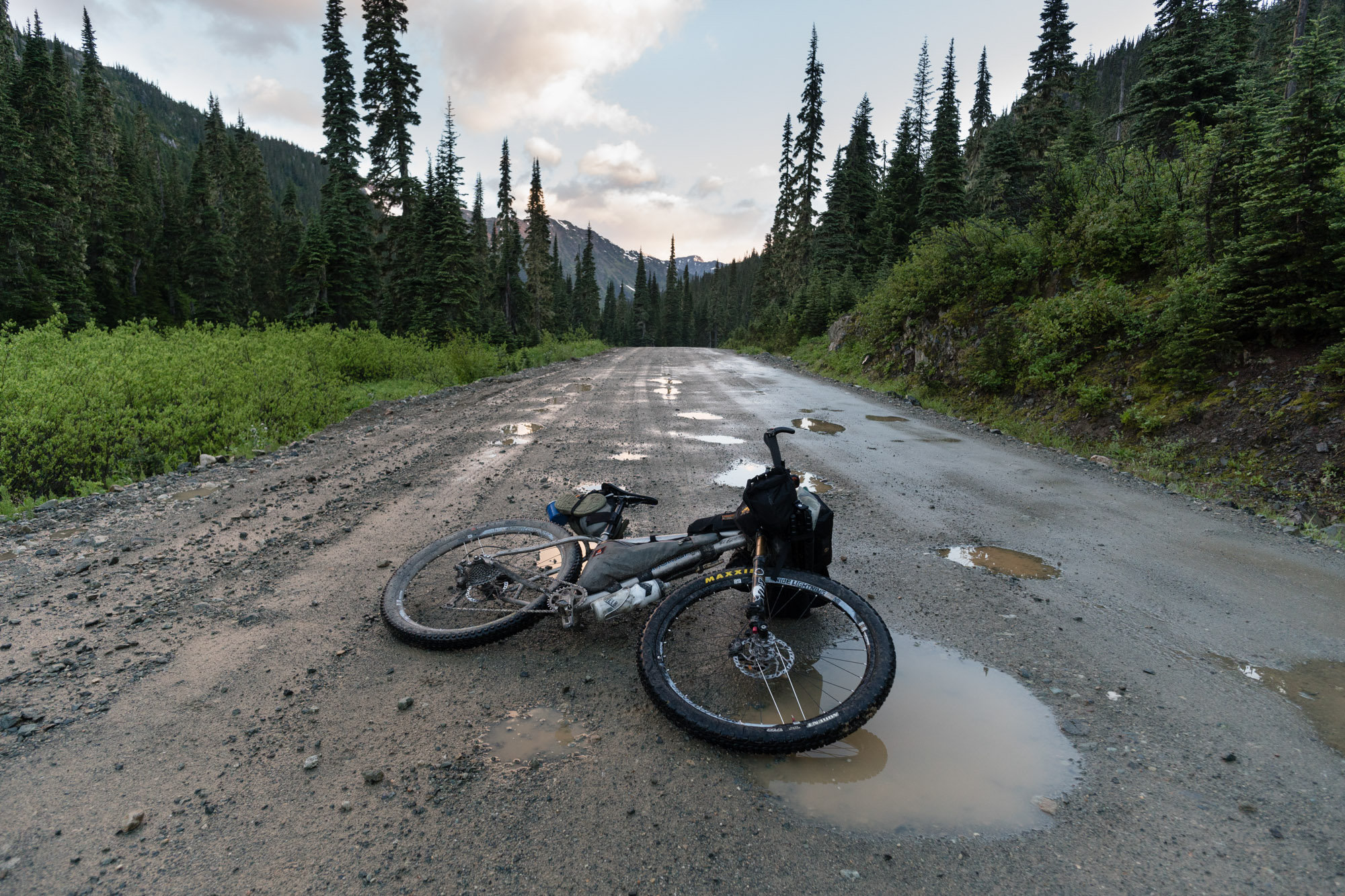 After riding through way more snow than I would have liked, I found that the trail I planned to take out of the park was in bad shape. With trees blocking the path and rain clouds rolling in, I made the decision to ride back to Pemberton that night. My final stretch was an 85 mile ride over 4 mountain passes, and back through the Hurley River road at night in the rain. I guess I'd had enough. I went from literally my highest point that day on Camel Pass to my lowest point wanting to go home. My first solo trip was a rewarding experience, but I think I'd like to come back and share those highs and lows with the company of good friends. This shot was at sunrise during my last descent on Hurly FSR into Pemberton Meadows.